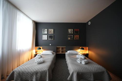 um quarto com duas camas com toalhas brancas em Hotel Navalis, Klaipėda em Klaipėda