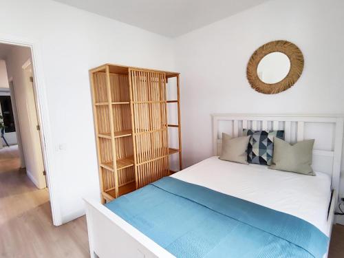 1 dormitorio con cama blanca y espejo en Elegant apartment with private workspace, en Candelaria