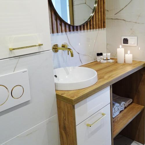 a bathroom with a sink and a mirror at Apartamenty u ROXI in Jelenia Góra