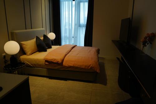 a bedroom with a bed with pillows and a television at The Ress - The Axon Bukit Bintang Residence in Kuala Lumpur