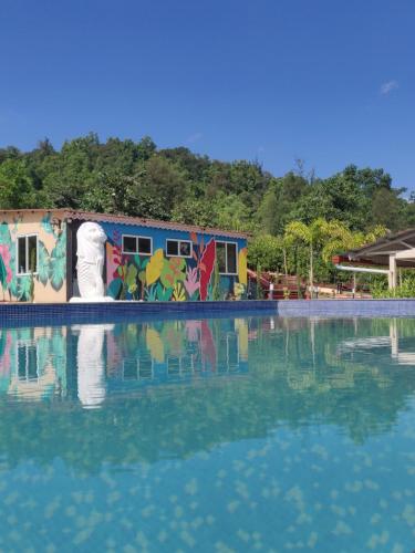 a pool of water with a building with graffiti at VRISA Mountain Retreat in Pune