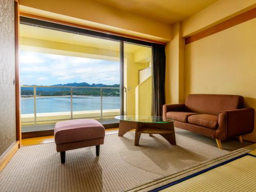 a living room with a couch and a table and a large window at KAMENOI HOTEL Nachi Katsuura Kumano Kodo in Nachikatsuura