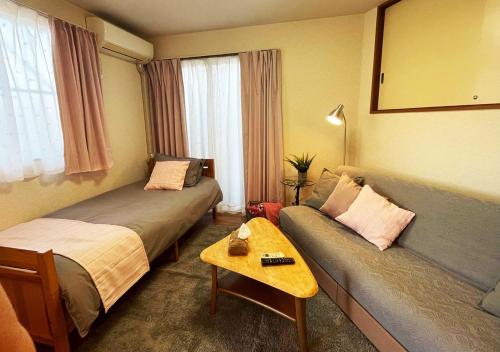 a hotel room with two beds and a couch at Yokohama Ivy 101 - 横浜 アイビー清水ヶ丘101 - in Yokohama