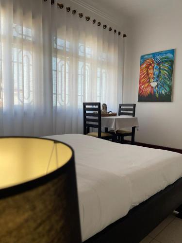 a bedroom with a bed and a table with chairs at The Jewel and the Lake in Jinja