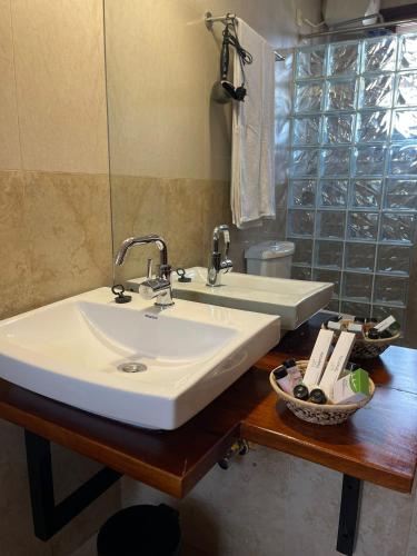 a bathroom with a white sink and a mirror at The Jewel and the Lake in Jinja