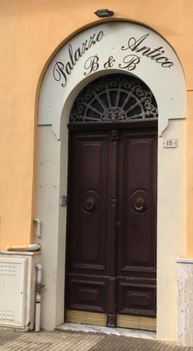 a large black door on the side of a building at b&b new antico palazzo in Parabita