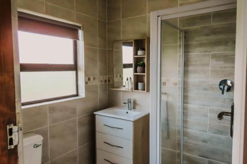 a bathroom with a sink and a shower at Aloe Corner, Cathkin Estates in Ardmore