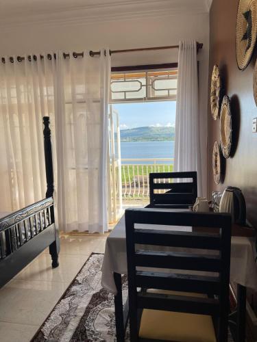 a dining room with a table and a view of the ocean at The Jewel and the Lake in Jinja
