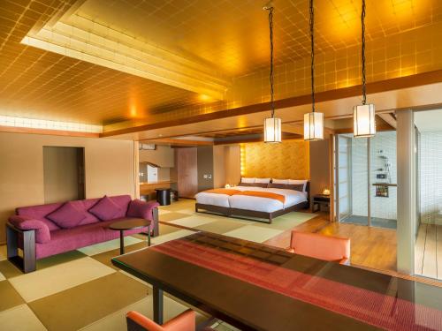 a bedroom with a bed and a couch and a table at KAMENOI HOTEL Nachi Katsuura Kumano Kodo in Nachikatsuura