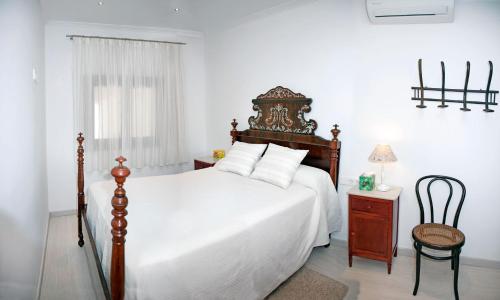 a bedroom with a large bed and a chair at Can Peret - Sa Pobla in Sa Pobla