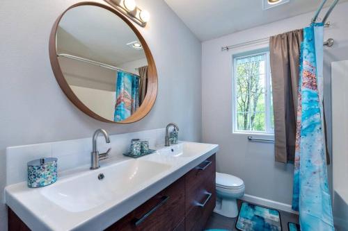 La salle de bains est pourvue d'un lavabo et d'un miroir. dans l'établissement TRANQUILITY VILLA: Serene relaxation place, à Snohomish