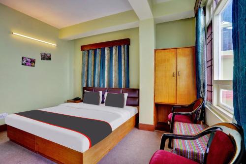 a bedroom with a bed and two chairs in it at Collection O Hotel Green Park in Gangtok