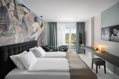 a bedroom with a bed and a large painting on the wall at Villa Monte Kope in Banjole