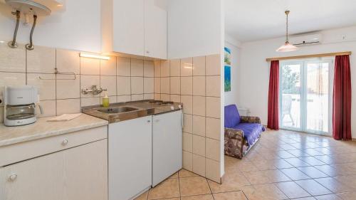 a kitchen with a sink and a couch in a room at Große Terrasse mit Meerblick, Strand 200 Meter in Baška