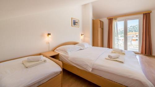 two beds in a room with a window at Große Terrasse mit Meerblick, Strand 200 Meter in Baška