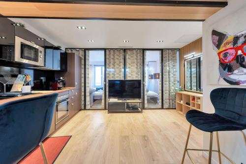 une cuisine avec deux chaises bleues et un salon dans l'établissement LE NAPOLEON chic et moderne, l'endroit parfait au cœur de la Banane, à Cannes