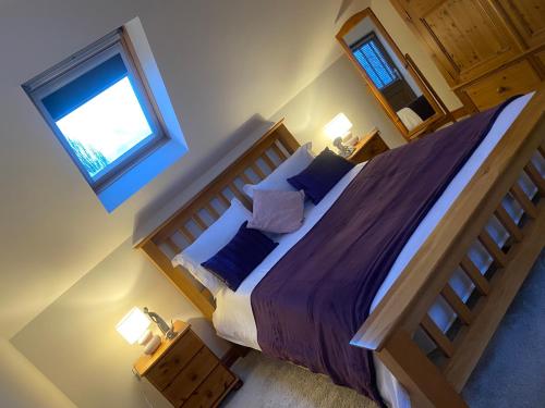 a bedroom with a large bed and a window at The Barn in Haxby