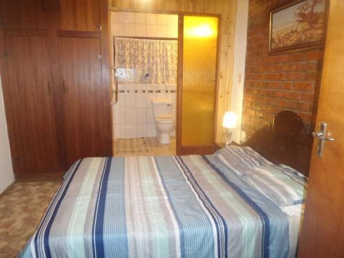 a bedroom with a bed and a bathroom with a toilet at Serendipity self catering one bedroom apartment in Despatch