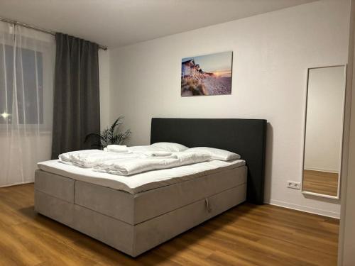 - une chambre avec un lit dans une pièce avec un miroir dans l'établissement FeWo Carl: Businessapartment mit Stil, à Bielefeld