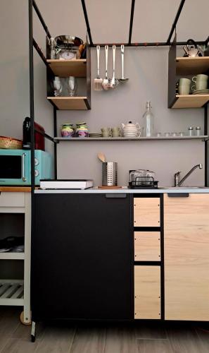 a kitchen with a black counter and shelves at Le Case di Ale - Via Posidonia - Holidayhome in Salerno in Salerno