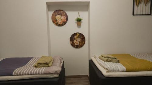 two beds in a room with two plates on the wall at APARTMENTS KREMSTAL in Imbach