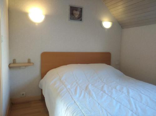 a bedroom with a bed and two lights on the wall at Charmant Appartement in Saint Malo