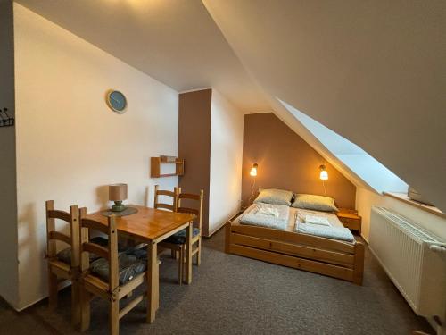 a bedroom with a bed and a table with a tableablish at Penzion Verde Rosa in Harrachov