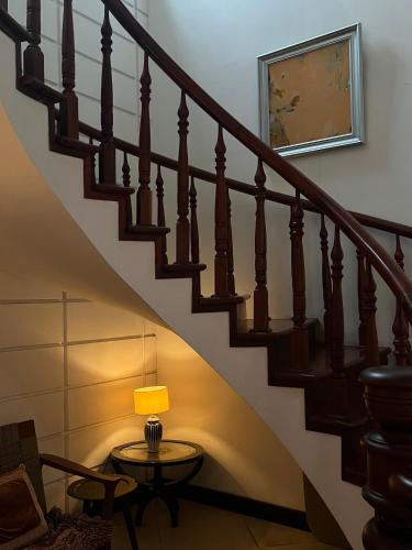 a staircase with a table and a lamp on it at The Mansion Hoi An by Minova in Hoi An