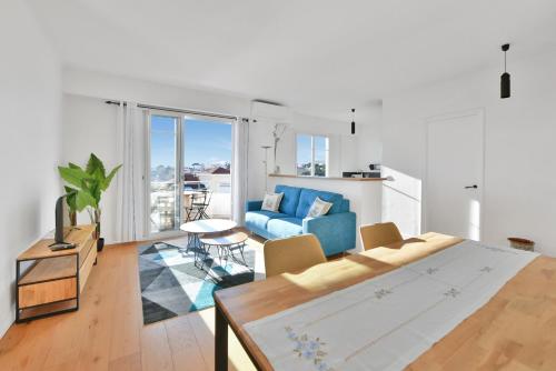 un salon avec un canapé bleu et une table dans l'établissement LE MARINE vue mer avec joli terrasse, un rêve pour les couples, à Cannes