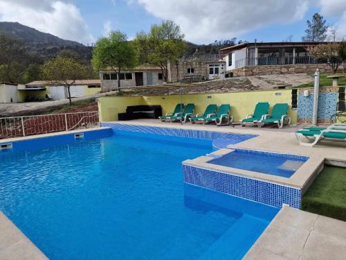 einen großen Pool mit Stühlen in der Unterkunft Quinta Do Moinho Turismo de Natureza in Aldeia Viçosa