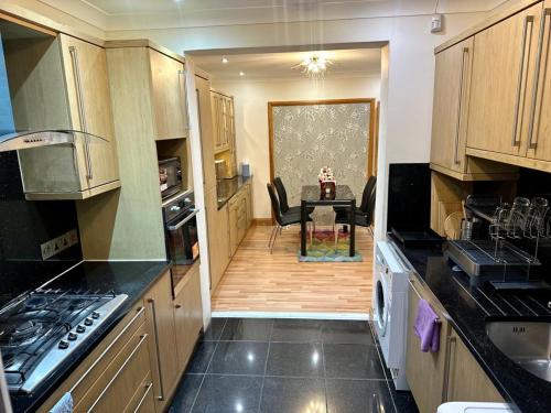 a kitchen with a table and a dining room at Elegant Square in Hither Green