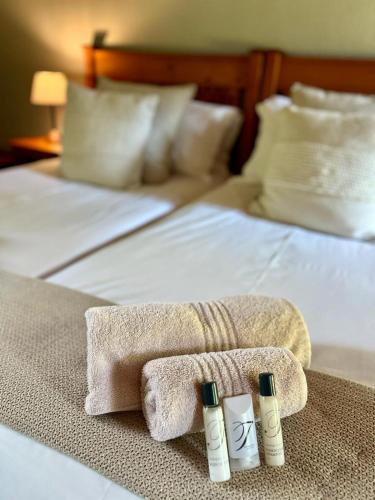 a hotel room with two towels on a bed at Linvale Country Lodge in Hazyview