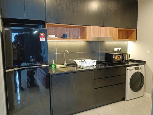 a kitchen with a sink and a washing machine at Axon Serviced Suites in Kuala Lumpur