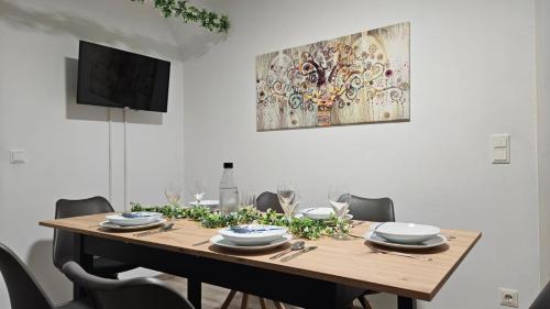 a dining room table with chairs and a painting on the wall at APARTMENTS KREMSTAL in Imbach