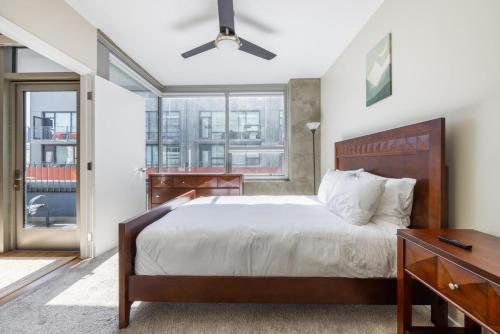 a bedroom with a bed and a desk and windows at East Village 1br w rooftop nr park bars SAN-40 in San Diego
