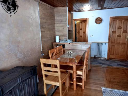 a dining room with a wooden table and chairs at Apartman Luka in Jahorina