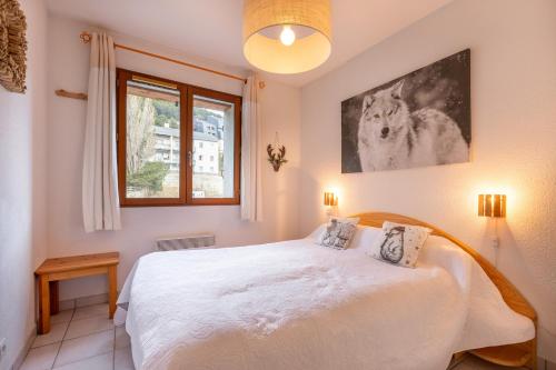 une chambre avec un lit blanc et une fenêtre dans l'établissement Le Refuge du Chevreuil - Pistes accessibles, aux Angles