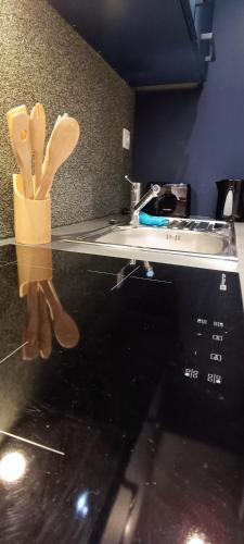 a counter with utensils on top of a microwave at Résidence Bel'Air in Aire-sur-la-Lys