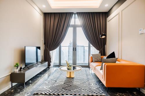 a living room with an orange couch and a tv at Royce KLCC Kuala Lumpur City Centre by Dormeo Destinations in Kuala Lumpur