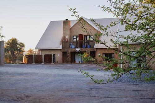 a large brick building with a roof at Eldorado Lodge CC in Kuruman