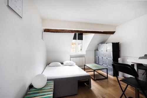 une petite chambre avec un lit et une table dans l'établissement Promo! Best location! Duplex apt near the Louvre, à Paris