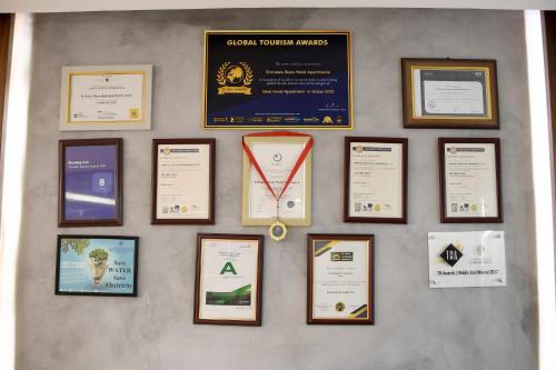 a wall with a bunch of certificates and medals at Emirates Stars Hotel Apartments Dubai in Dubai