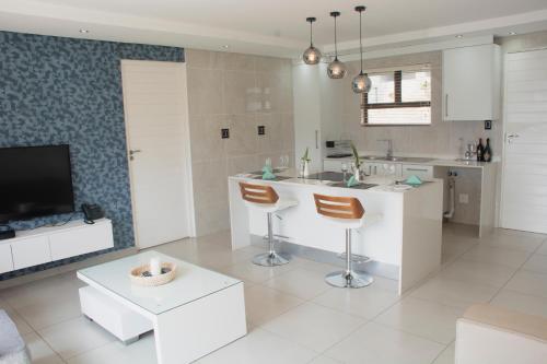 a white kitchen with a sink and a counter at Impecto Guest House in Jozini