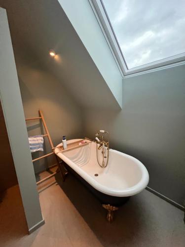 a bath tub in a bathroom with a skylight at Modern house by the Fjord in Sandane, Nordfjord. in Sandane