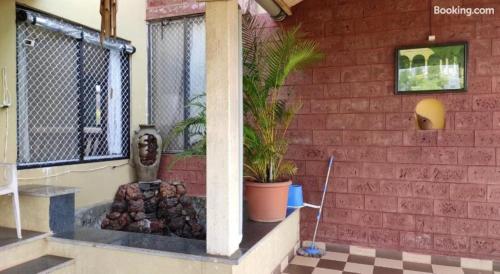 a brick wall with potted plants on a porch at Sai Sadan Residency,Diveagar in Diveagar
