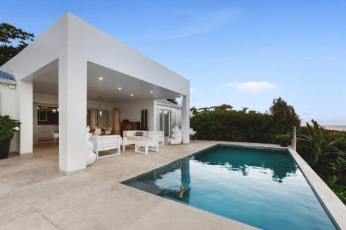 eine Villa mit einem Pool vor einem Haus in der Unterkunft Grand Case - Villa chic 6p 3ch 3sdb Vue panoramique in Saint Martin