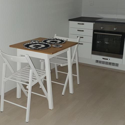 eine Küche mit einem Tisch, Stühlen und einem Herd in der Unterkunft Cozy Studio in Espoo NEW in Helsinki