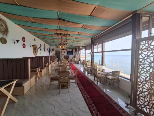 a dining room with chairs and tables and windows at PLAYA Hôtel & Restaurant Dakhla in Dakhla