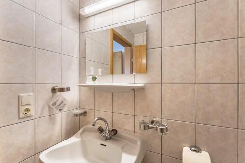 ein Bad mit einem Waschbecken und einem Spiegel in der Unterkunft Schwüwong - Apartment 01 in Kelchsau
