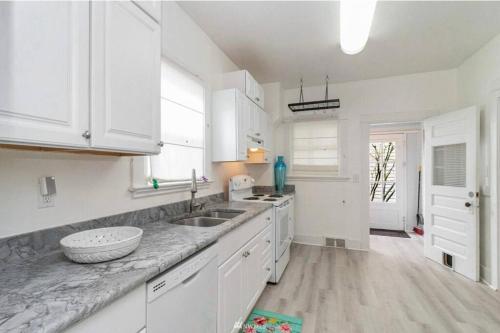 a kitchen with white cabinets and a marble counter top at Victorian Villa: Interns or family in Seattle